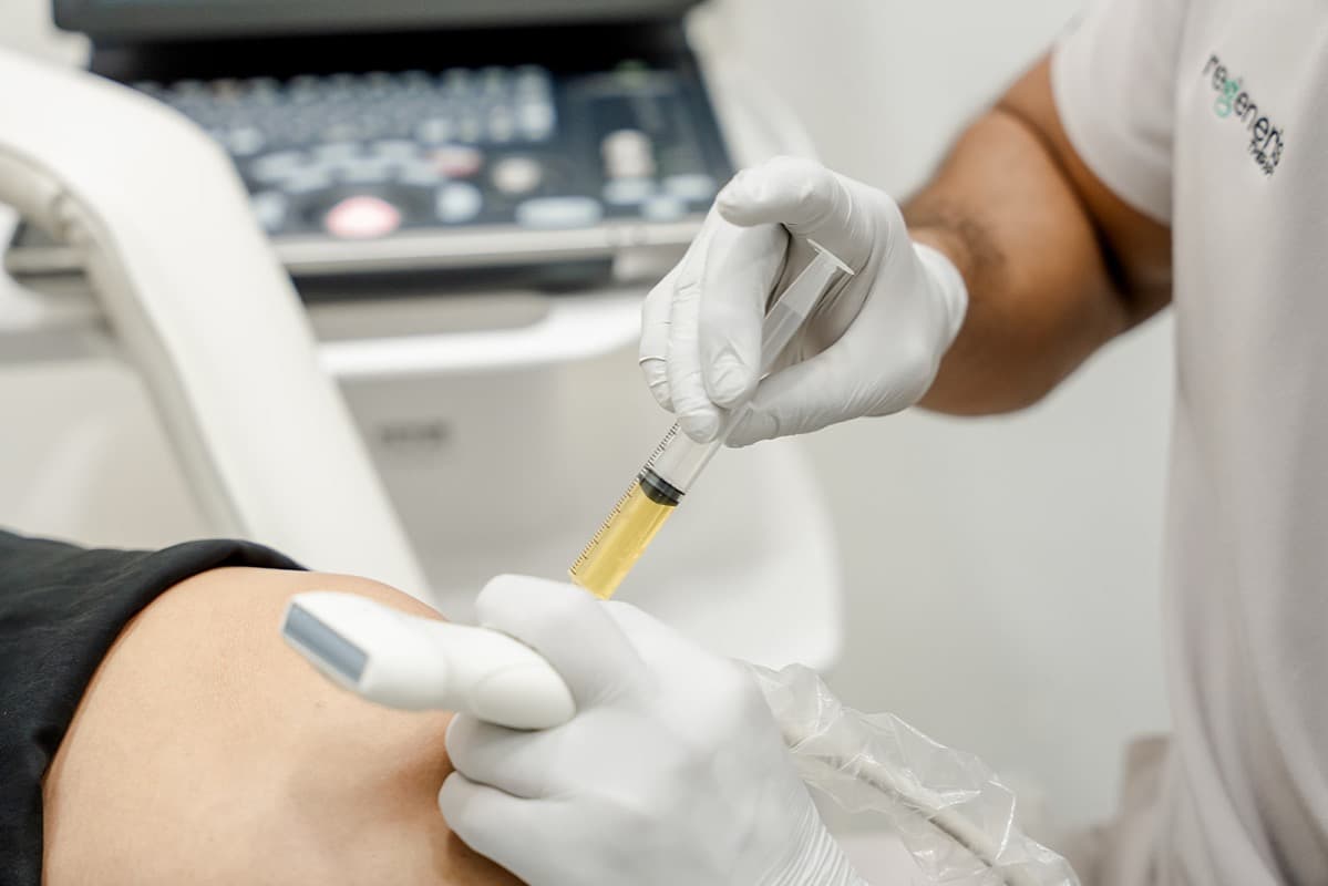 Medical professional preparing a PRP (Platelet-Rich Plasma) injection in a sterile clinical setting.